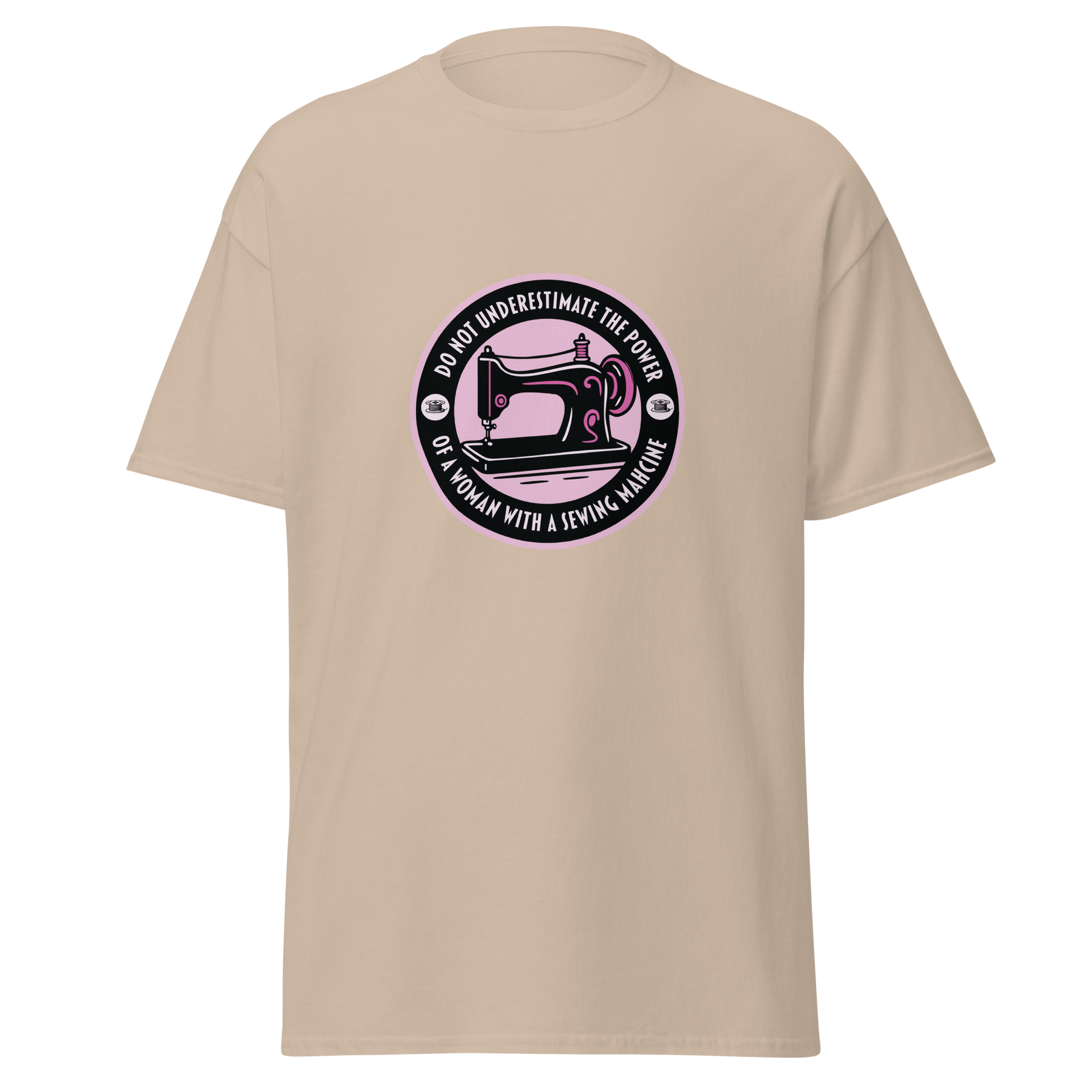 Beige unisex huumoripaita, jonka keskellä pinkki ympyräpainatus. Kuvassa ompelukone, kehällä mustalla teksti “Do not underestimate the power of a woman with a sewing machine” – kielletään kaikki